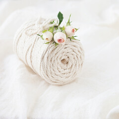 Handmade macrame braiding and cotton threads with rose flower. Image good for macrame and handicrafts banners and advertisement.  Top view. Copy space