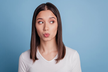 Obraz premium Closeup photo of attractive young woman sending air kisses romantic flirty look empty space isolated blue color background