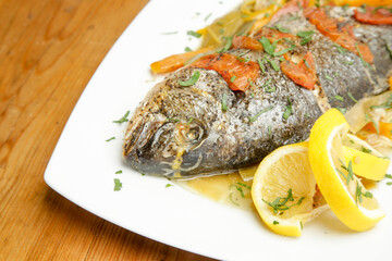 Grilled fish with tomato sauce and lemon slices