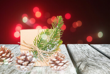 Gift box on abstract glitter lamps background.Christmas blurred background, Gift box,cone,fir branch,wooden tables.Copy space.