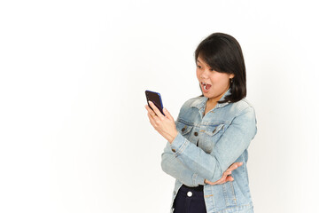 Fototapeta premium Holding and Using Smartphone of Beautiful Asian Woman Wearing Jeans Jacket and black shirt Isolated On White Background