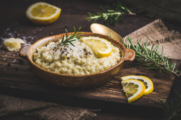 Lemon rice risotto with rosemary on dark wooden background