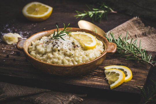 Lemon rice risotto with rosemary on dark wooden background