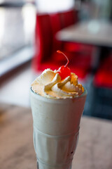 gros plan d'un milkshare vue d'en haut avec cerise sur de la chantilly dans un verre d'un restaurant