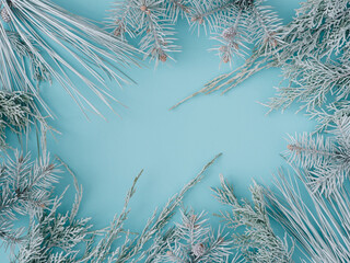 Creative christmas frame from white fir tree branches on pastel blue background with space for text. Merry Christmas and Happy New Year. Xmas concept. Top view. Flat lay. Copy space.