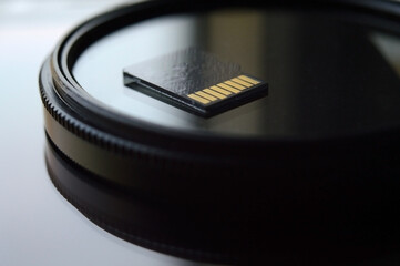 micro sd card for use in photo and video technology. micro sd lies on the lens filter. close-up.