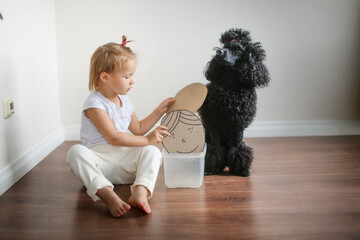 Dog therapy, a child and a black poodle dog with cards with emotions, containment of emotions....