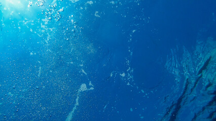 Fototapeta na wymiar View of Air Bubbles underwater. Blue water and sun. Adriatic Sea