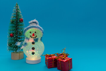 Glows in the dark snowman, presents and Christmas tree with copy space.new year celebration.