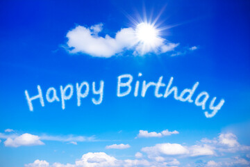 Happy Birthday written on a sunny blue sky, symbol for best wishes for a carefree special day with...