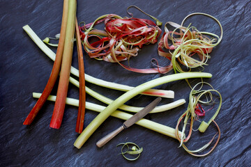 Peeled and unpeeled rhubarb on slate