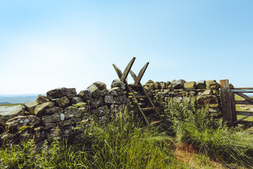 Traditional British stone wall with wooden ladder style in countryside