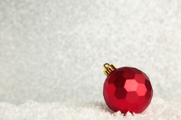 Red Christmas ball on glittering background. New Year 2022