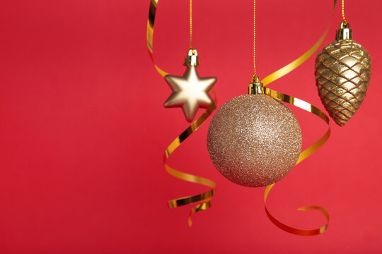 Golden christmas ball with ribbon on red background with copy space. New Year 2022