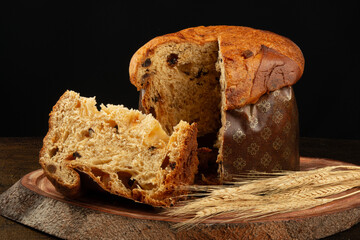 panettone with sliced traditional christmas food piece with black background.
