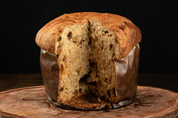 panettone with sliced traditional christmas food piece with black background.