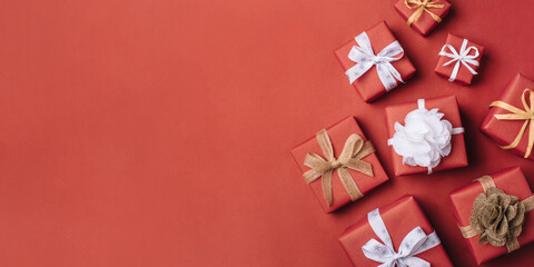 Gift boxes with white and brown bows on a red backdrop.