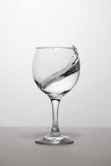 Wineglass with white wine with splash	