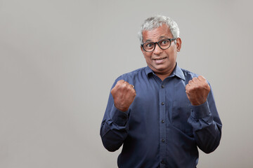 Senior man of Indian origin with a cheering expression