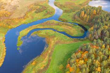 Beautiful early autumn landscape, field, river and colorful forest. Pushkinskie Gory, Pskov Region Russia. top areal view from a drone