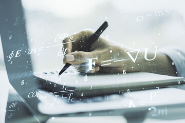Creative scientific formula illustration with hand writing in diary on background with laptop,...