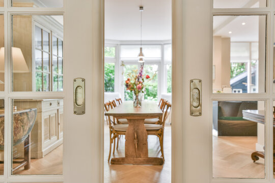 Modern dining room interior with wooden furniture on parquet