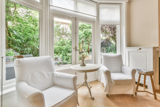 Modern room interior with furniture against windows in house