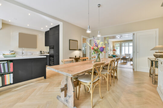 Modern dining room interior with wooden furniture on parquet