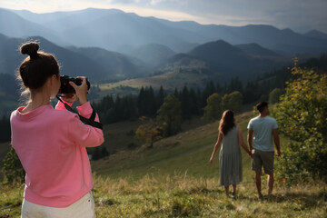 Fototapeta na wymiar Professional photographer taking picture of couple in mountains