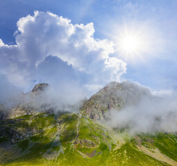 green mountain valley in dense clouds at the sunny day, natural travel background