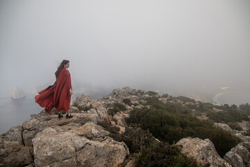 Woman in old fashioned clothes on rocky shore