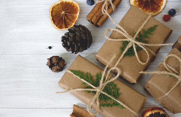 Christmas composition. Christmas gifts, pine cones, fir branches on white wooden background. 