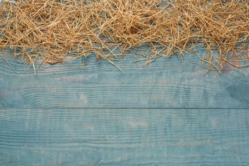 Heap of dried hay on light blue wooden background, flat lay. Space for text