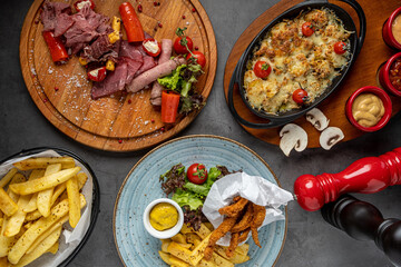 antipasti, chicken fillet and casserole mushrooms on stone table