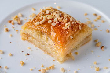 Turkish baklava with hazelnuts on a white porcelain plate