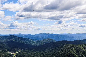 Clouds over mountains with kites