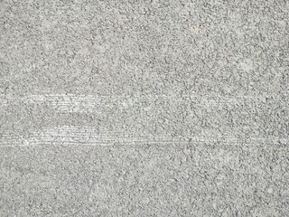 Tire tracks of a car tread with winter spikes on bare asphalt