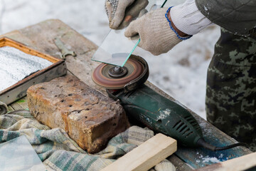 man polishes glass on grinding machine. Glass processing at home. Private business in rural conditions.