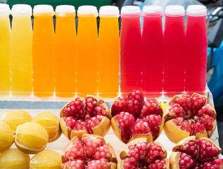 Fresh pomegranate juice and orange juice packaged in plastic bottles are sold in food streets. Bangkok, Thailand.