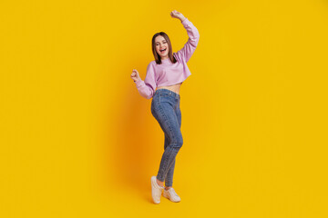 Fototapeta na wymiar Full body photo of young cheerful girl rejoice victory fists ahnds lucky isolated over yellow color background