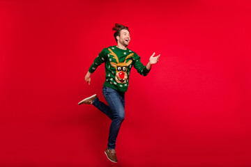 Full size photo of smiling good mood guy running fast speed in air wear ugly sweater isolated on red color background