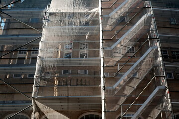 Erhaltung alter Bausubstanz durch Renovierung mit Baugerüst und Schutznetz an einem Altbau in der Altstadt von Münster in Westfalen im Münsterland