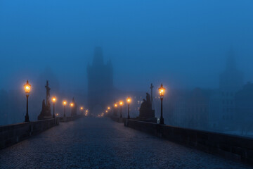Fototapeta na wymiar Foggy morning twilight on the famous Charles Bridges in the Czech Republic - the city of Prague