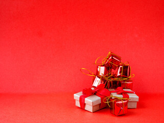 Christmas gift boxes wrapped in red paper on red background. Side view copy space, minimalism, monochrome