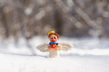 Christmas angel with a gift in the snowy forest.