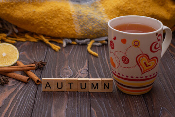 Autumn fall flat lay, top view. Autumn leaves, a mug of tea. with the inscription hello autumn on a rustic wooden background