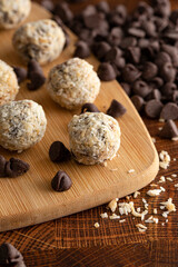 Group of Coconut Chocolate Energy Balls on a Wooden Butcher Block