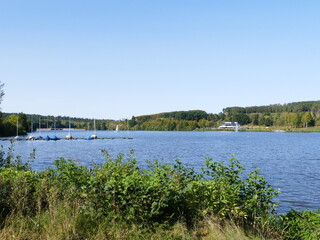 View of the first basin of the Sorpe Lake, North Rhine-Westphalia, Germany, on the left the small sailing boat harbor, in the background the first dam of the reservoir