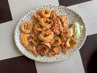 Crispy squid rings on a platter with garlic and mustard sauces