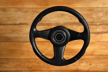 New black steering wheel on wooden background
